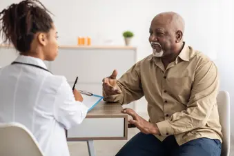photo of older black man talking to a doctor