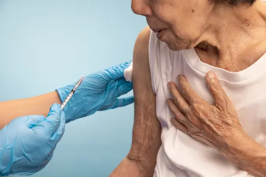 photo of older woman getting vaccine