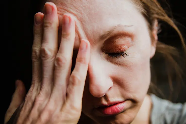 photo of woman rubbing head