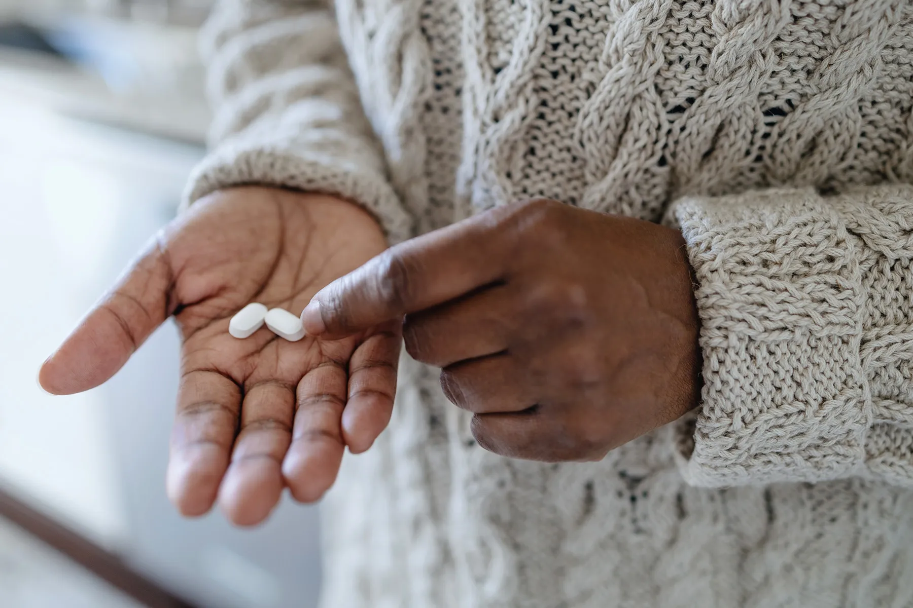 photo of woman putting pills in hand