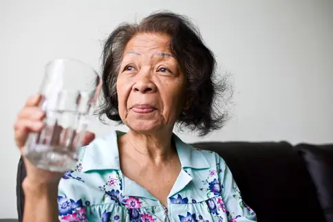 photo of senior woman drinking glass of water