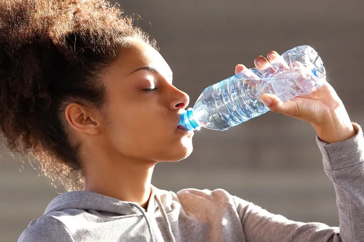 photo of woman drinking bottled water