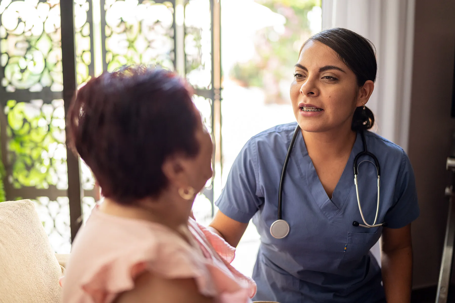 photo of home caregiver talking with patient