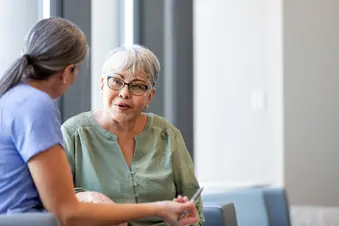 photo of doctor listening to question from patient