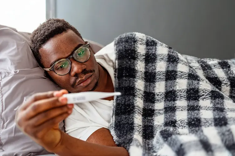 photo of sick man checking temperature