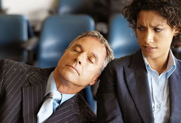 man asleep on woman’s shoulder