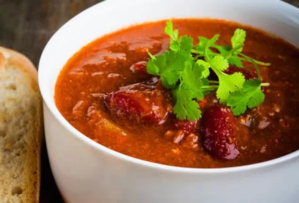 Bowl of chili with cilantro and bread