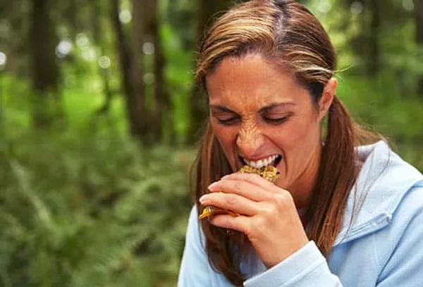 Dissatisfied woman biting into a granola bar
