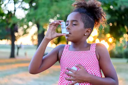 photo of little girl using inhaler