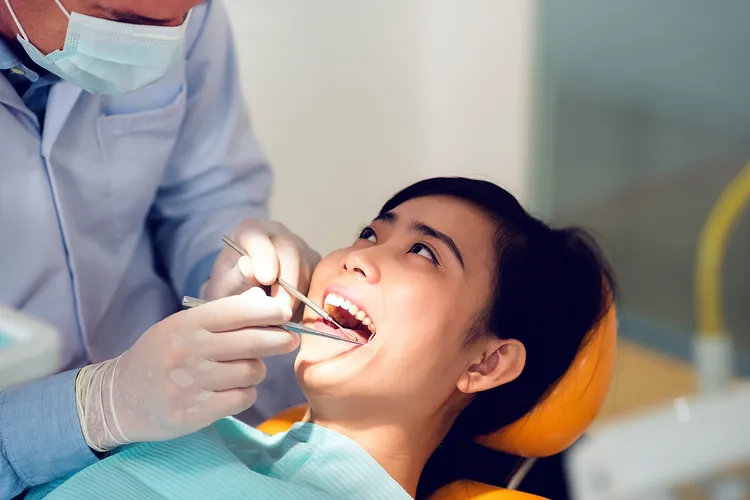 photo of dentist examining teeth of female patient
