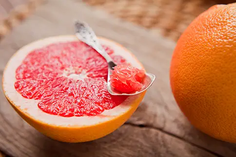 photo of Pink grapefruit on wooden table