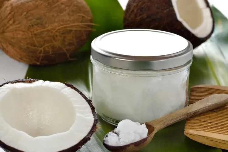 photo of coconut half and jar of oil