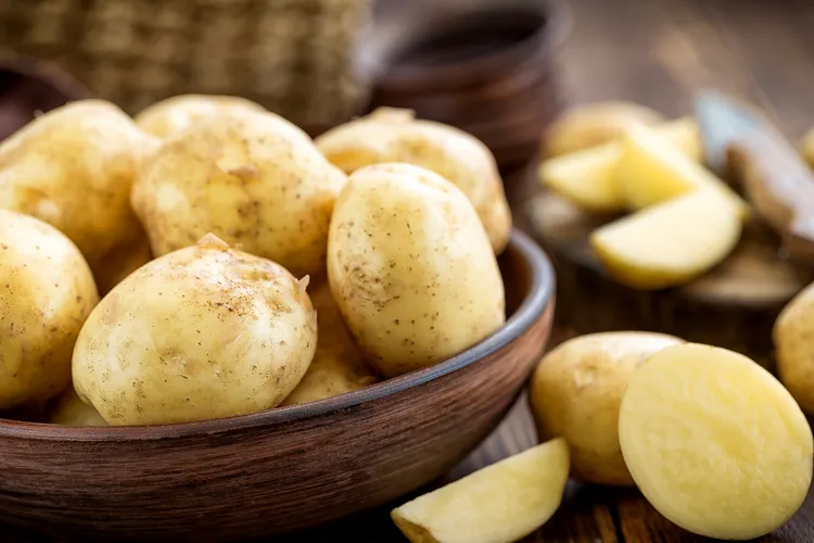 photo of wooden bowl of potatoes on table