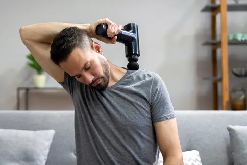 photo of using massage gun on shoulder