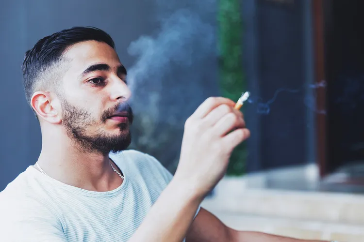 photo of young man smoking cigarette
