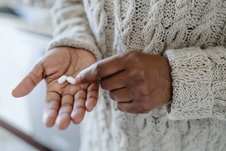 photo of person with pills in hand