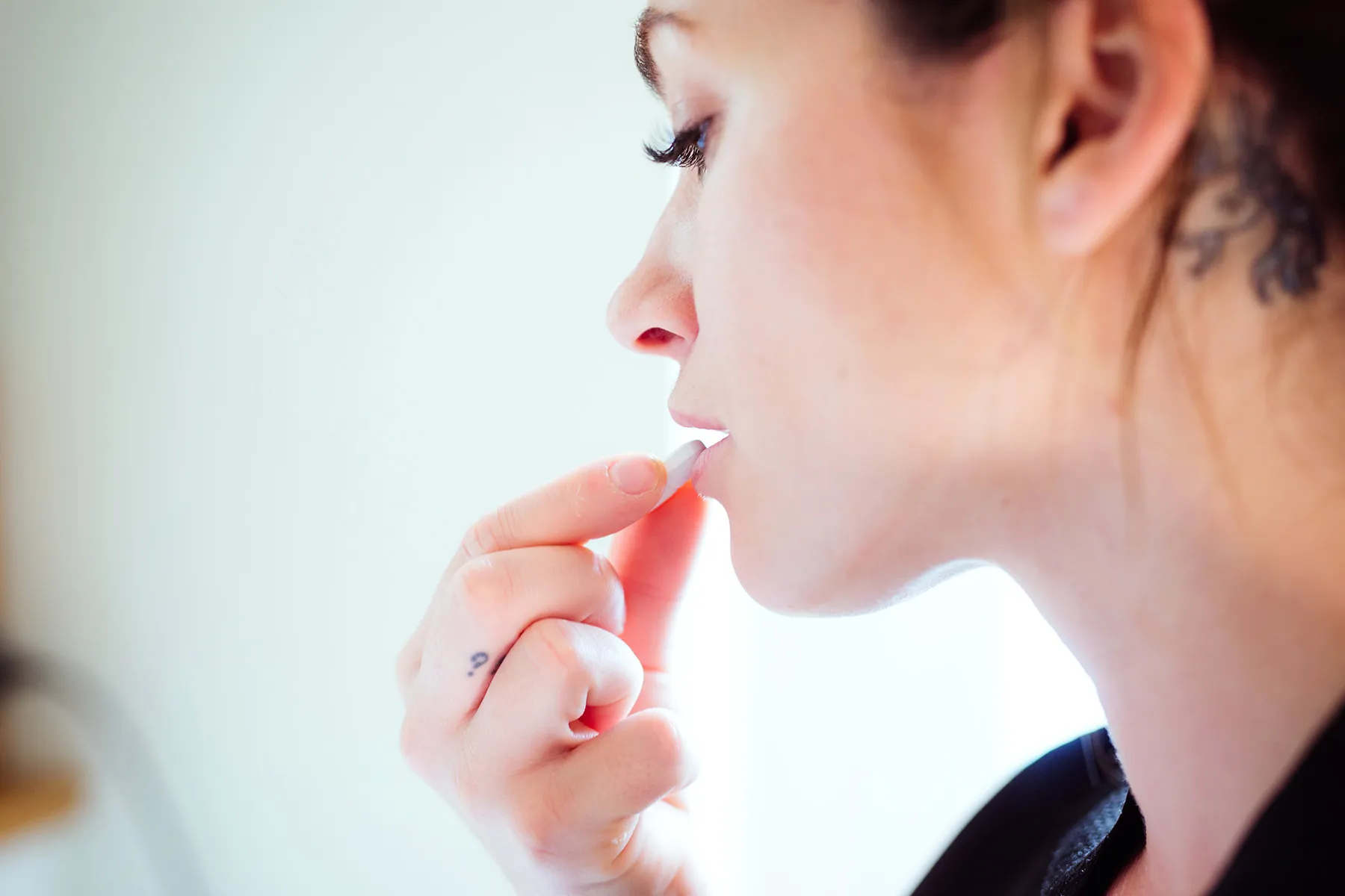 photo of woman taking pill