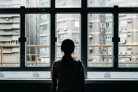 photo of woman looking out window