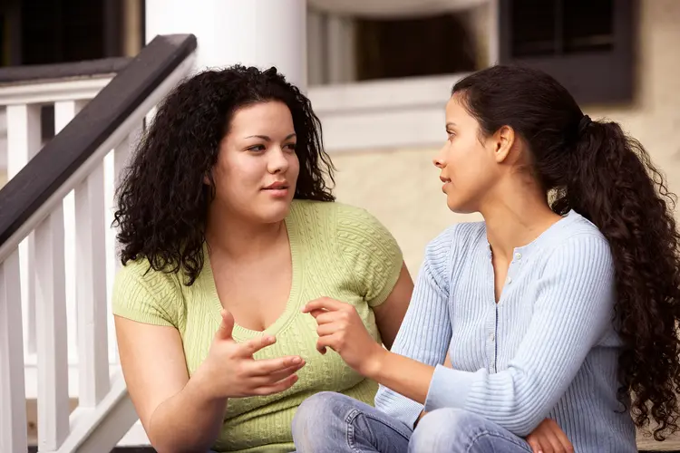 photo of friends having conversation on porch