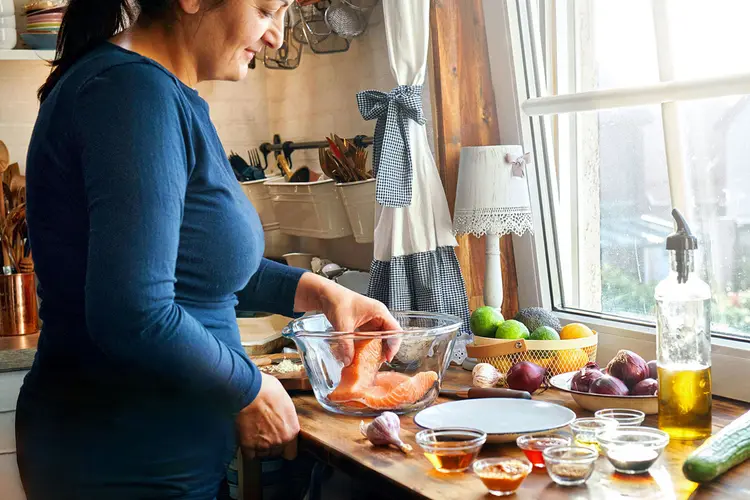 photo of woman preparing salmon meal
