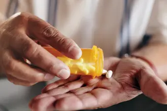 photo of man pouring medication into hand