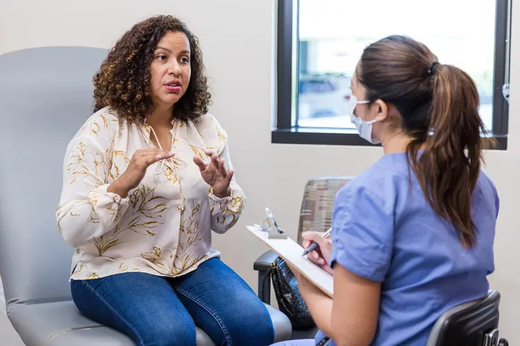 photo of female patient explaining symptoms to doctor