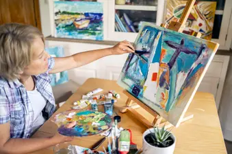 photo of mature woman painting on canvas