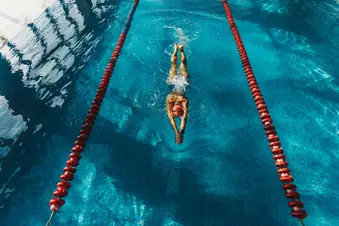 photo of woman swimming in lane