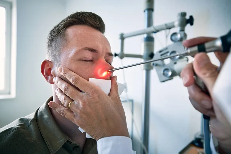 photo of doctor examining nose