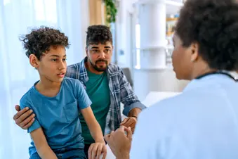 photo of parent and child listening to doctor