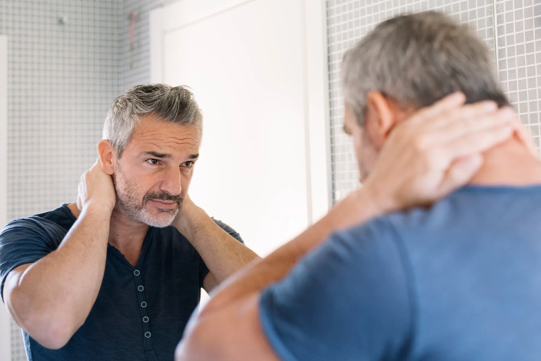 photo of man looking in mirror
