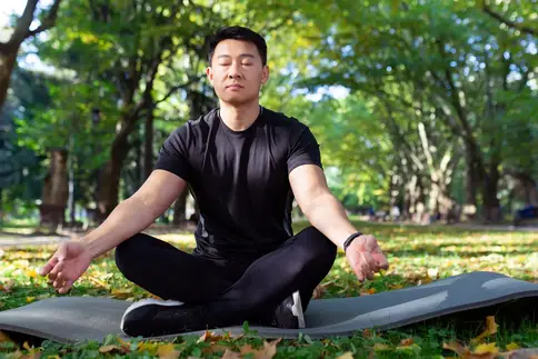 photo of man holding yoga pose in park