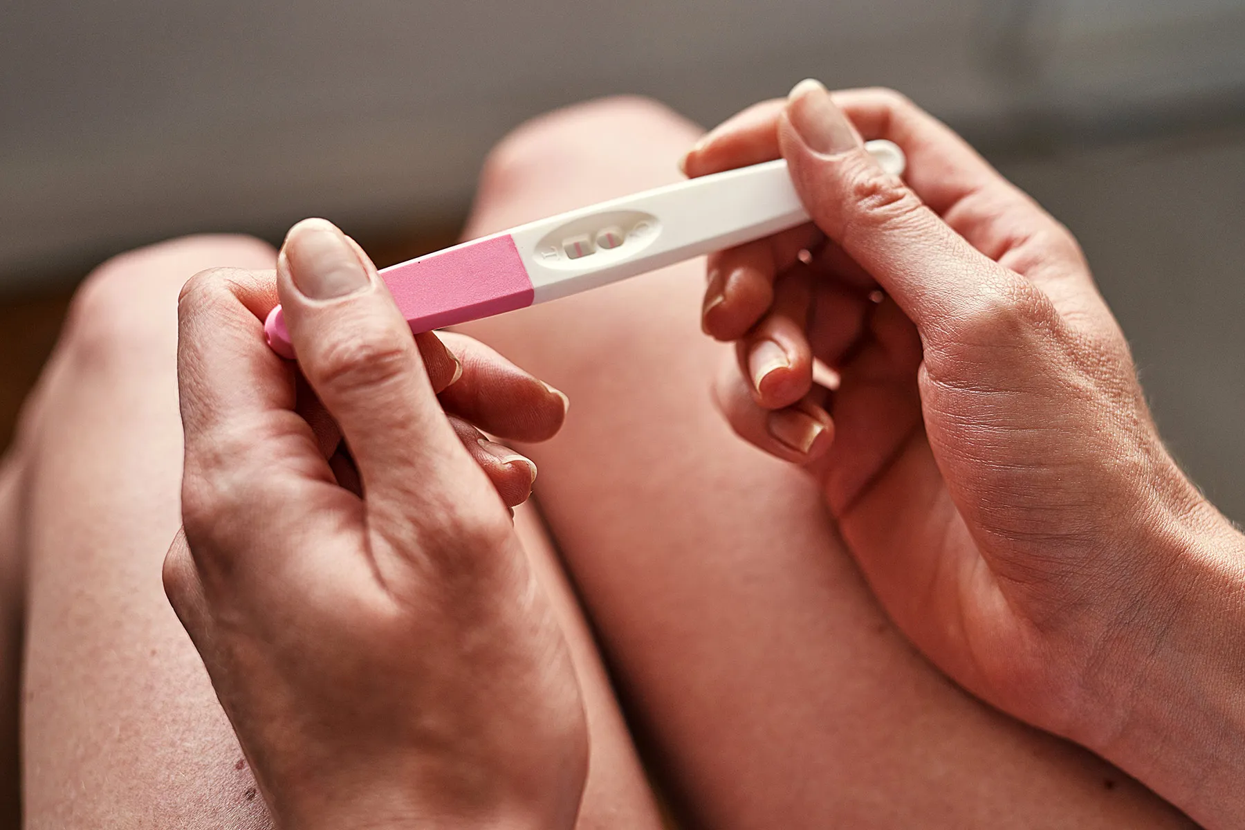 photo of woman holding pregnancy test stick