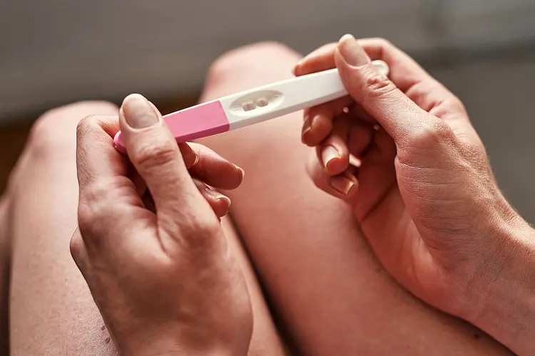 photo of woman holding pregnancy test stick