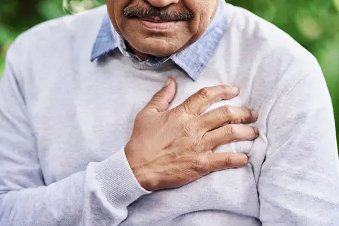 photo of mature man holding chest