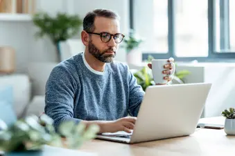 photo of 40s man doing research on laptop