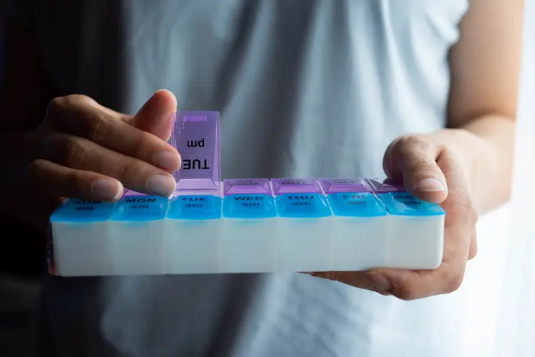 photo of man holding pill organizer