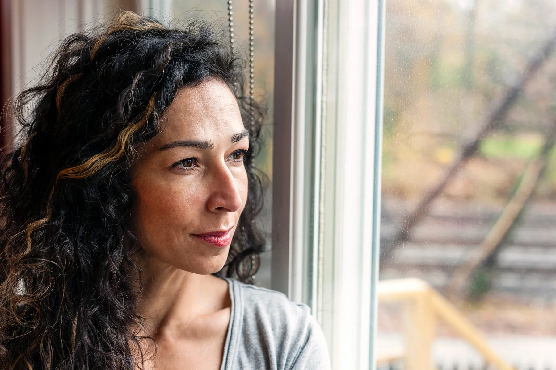 photo of mature woman gazing out window