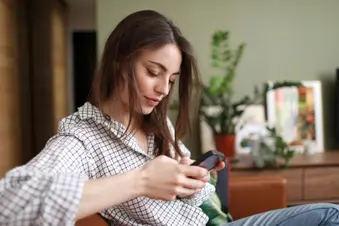 photo of young woman surfing on smartphone at home