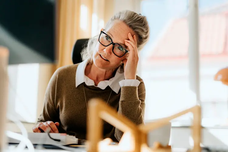 photo of exhausted businesswoman at office desk