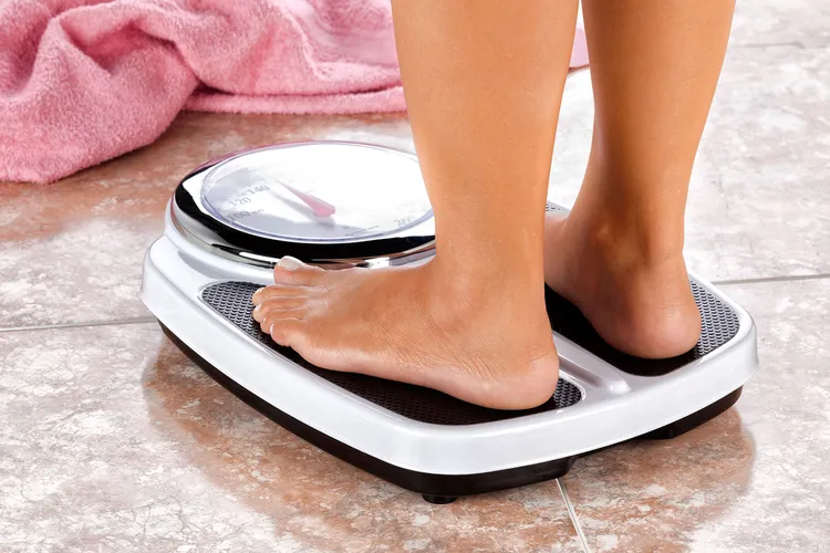 photo of woman standing on weight scale