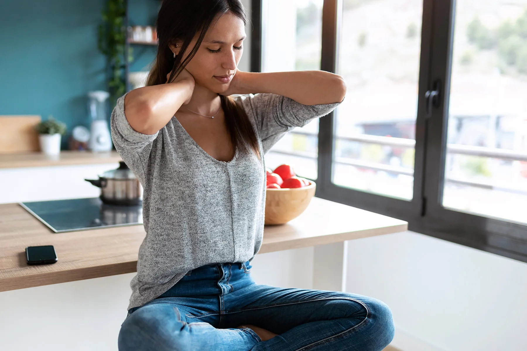 photo of woman massaging sore neck