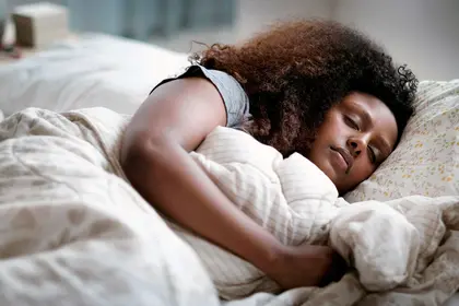 photo of young woman asleep in bed