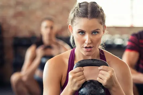 photo of exercising with kettlebell in gym