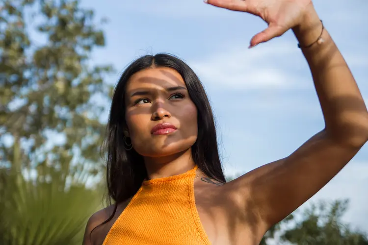 photo of woman shielding eyes from sun.