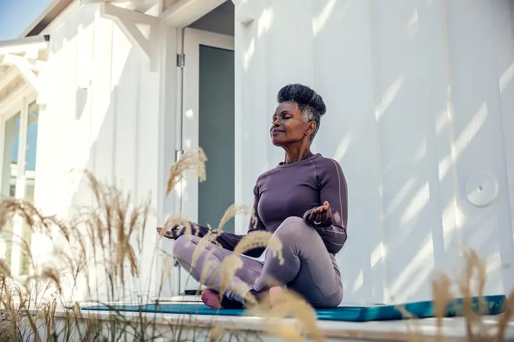 photo of woman meditating on porch