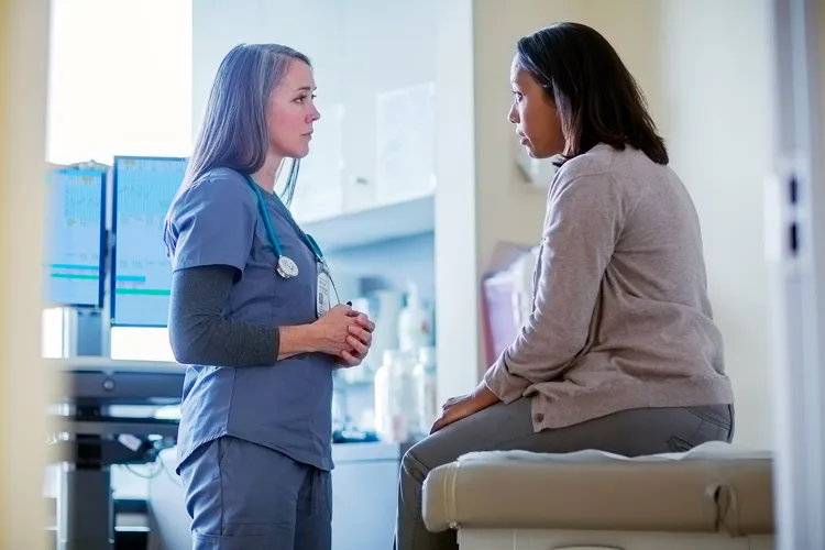 photo of doctor talking with female patient