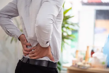 Lower back pain is a common symptom you might have with a kidney infection. (Photo credit: Moment/Getty Images)