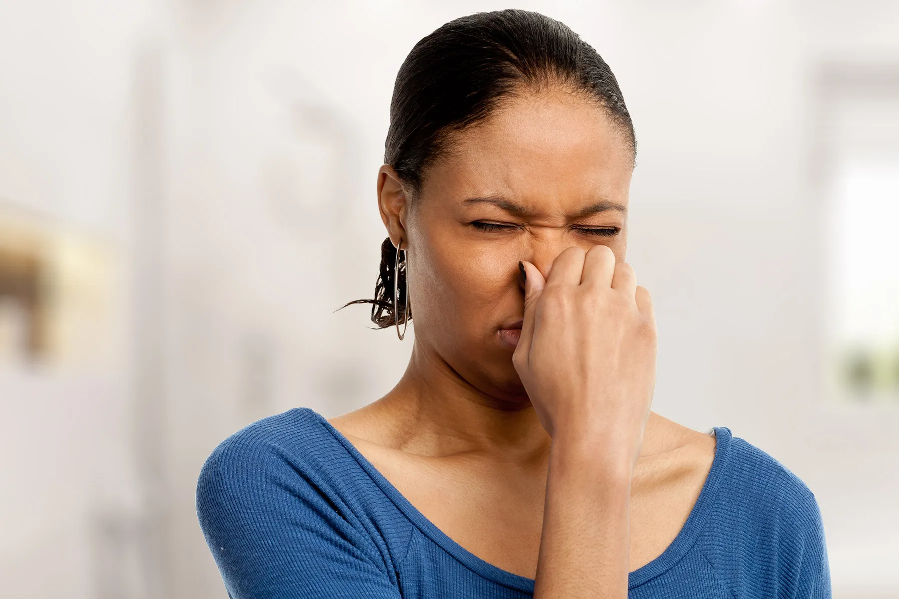 photo of woman holding her nose