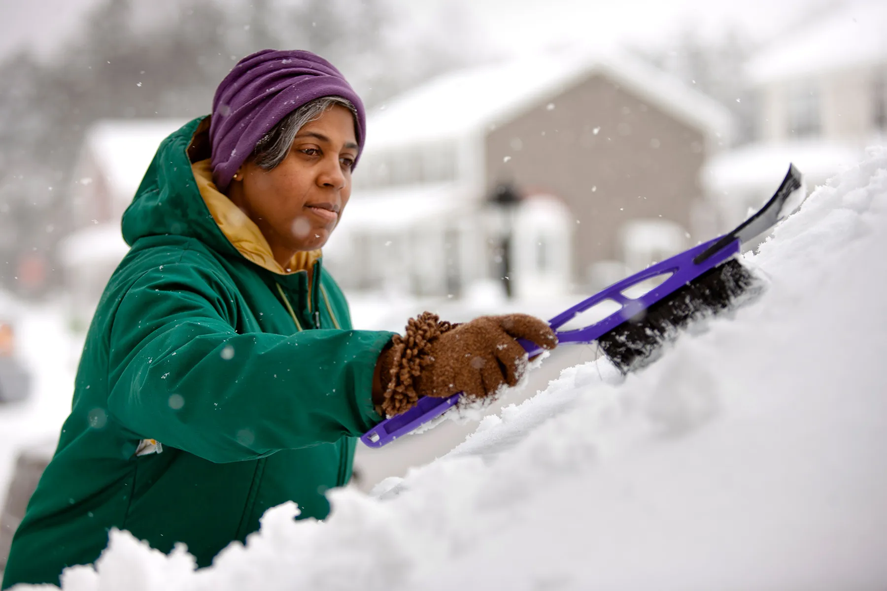 photo of woman scraping snow from windshield